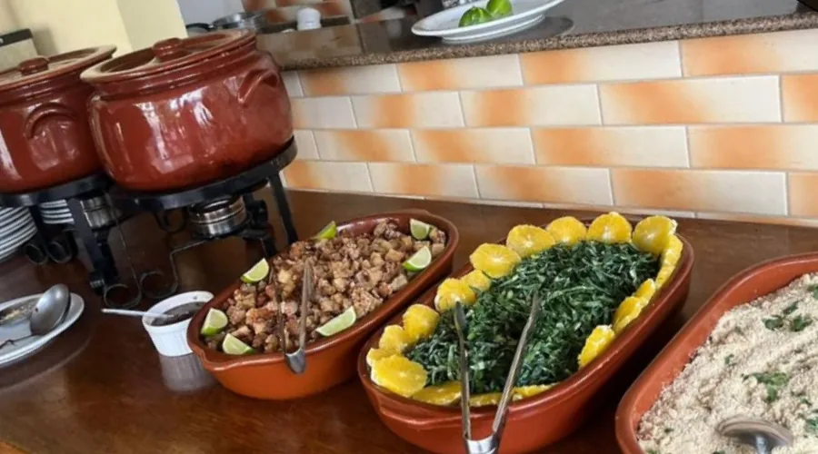 Feijoada completa do Encanto Gourmet servida em rechaud de cerâmica com acompanhamentos
